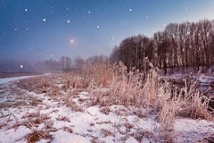 Nuit de Noël magique d'hiver Scène de chutes de neige sur une rivière photographie stock libre de droits Nuit de Noël magique d'hiver Scène de chutes de neige sur une rivière photographie stock libre de droits