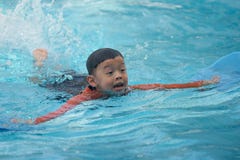Nuoto asiatico del ragazzo nello stagno di acqua fotografia stock Nuoto asiatico del ragazzo nello stagno di acqua fotografia stock