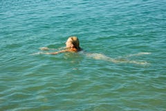 Nuoto dell'adolescente in acqua di mare fotografia stock Nuoto dell'adolescente in acqua di mare fotografia stock