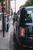 Nuova carrozza elettrica del nero di LEVC TX Londra che fa pagare dal punto di cambiamento a Londra, Regno Unito fotografia stock libera da diritti Nuova carrozza elettrica del nero di LEVC TX Londra che fa pagare dal punto di cambiamento a Londra, Regno Unito fotografia stock libera da diritti