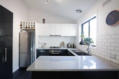 Nuova cucina contemporanea in bianco e nero con le mattonelle del sottopassaggio immagine stock libera da diritti Nuova cucina contemporanea in bianco e nero con le mattonelle del sottopassaggio immagine stock libera da diritti