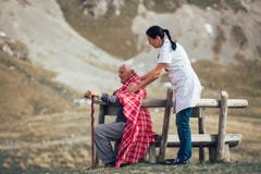 Nurse helping elderly senior man to walk on frash air Stock Photography Nurse helping elderly senior man to walk on frash air Stock Photography