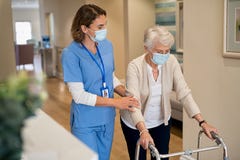 Nurse helping senior woman walk at nursing home