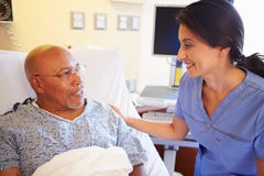 Nurse Talking To Senior Male Patient In Hospital Room