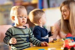 Nursery children playing with teacher in kindergarten stock images Nursery children playing with teacher in kindergarten stock images