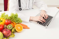Nutricionista fêmea irreconhecível que trabalha no portátil fotos de stock Nutricionista fêmea irreconhecível que trabalha no portátil fotos de stock