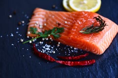 Ny laxfilé på mörkt bakgrundsslut upp av rå laxfiskskaldjur med citronört- och kryddachili royaltyfri fotografi Ny laxfilé på mörkt bakgrundsslut upp av rå laxfiskskaldjur med citronört- och kryddachili royaltyfri fotografi