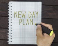 Nytt daglivbegrepp Hand som skriver nytt dagplan på en notepad arkivbilder Nytt daglivbegrepp Hand som skriver nytt dagplan på en notepad arkivbilder