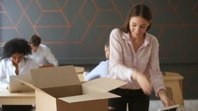 Nytt jobbbegrepp, ung kvinna som packar upp asken på kontorsskrivbordet Nytt jobbbegrepp, ung kvinna som packar upp asken på kontorsskrivbordet