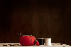 Nähende Versorgungen auf einer Tabelle einschließlich ein Tomatennadelkissen, -nadeln, -faden, -stifte und -knöpfe; lizenzfreie stockfotos Nähende Versorgungen auf einer Tabelle einschließlich ein Tomatennadelkissen, -nadeln, -faden, -stifte und -knöpfe; lizenzfreie stockfotos