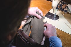 Nähender Prozess des Ledergürtels die Hände des alten Mannes hinter dem Nähen Lederne Werkstatt Textilweinlesenähen industriell lizenzfreies stockfoto Nähender Prozess des Ledergürtels die Hände des alten Mannes hinter dem Nähen Lederne Werkstatt Textilweinlesenähen industriell lizenzfreies stockfoto
