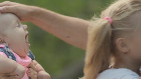 Närbild av den lyckliga familjen med två små flickor på Närbild av den lyckliga familjen med två små flickor på