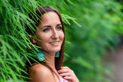 Närbild av en stående av en flicka med ett leende nära ett naturligt staket av gräs fotografering för bildbyråer Närbild av en stående av en flicka med ett leende nära ett naturligt staket av gräs fotografering för bildbyråer