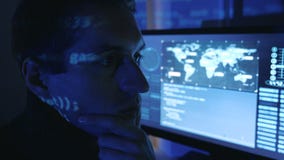 Närbildstående av en yrkesmässig bärareprogrammerare för man i en datorhall som fylls med bildskärmskärmar En hackerarbeten arkivfilmer Närbildstående av en yrkesmässig bärareprogrammerare för man i en datorhall som fylls med bildskärmskärmar En hackerarbeten arkivfilmer