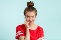Nätt ung flicka som rymmer hennes finger på en mun och ser kameran royaltyfria bilder Nätt ung flicka som rymmer hennes finger på en mun och ser kameran royaltyfria bilder