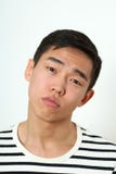 Nöjd ung asiatisk man som ser kameran arkivfoto Nöjd ung asiatisk man som ser kameran arkivfoto
