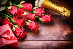 O ajuste do Valentim com rosas vermelhas, champanhe e presente Foto de Stock O ajuste do Valentim com rosas vermelhas, champanhe e presente Foto de Stock