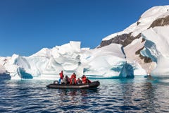 O barco completamente dos turistas explora os iceberg enormes que derivam na baía imagens de stock royalty free O barco completamente dos turistas explora os iceberg enormes que derivam na baía imagens de stock royalty free
