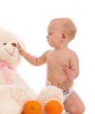 O bebé traz duas laranjas ao urso favorito imagem de stock O bebé traz duas laranjas ao urso favorito imagem de stock