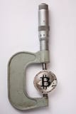O bitcoin é medido com um micrômetro imagens de stock O bitcoin é medido com um micrômetro imagens de stock