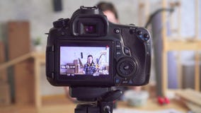 O blogger bonito novo da mulher DIY escreve o vídeo na oficina da garagem usando a ferramenta video estoque O blogger bonito novo da mulher DIY escreve o vídeo na oficina da garagem usando a ferramenta video estoque