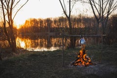 O bule no fogo prepara o chá Por do sol alaranjado imagem de stock O bule no fogo prepara o chá Por do sol alaranjado imagem de stock