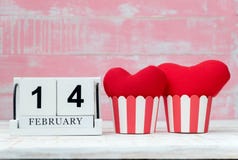 O calendário de madeira o 14 de fevereiro, dois corações vermelhos foi colocado de lado a lado e o fundo é cor-de-rosa Dia do Val imagens de stock royalty free O calendário de madeira o 14 de fevereiro, dois corações vermelhos foi colocado de lado a lado e o fundo é cor-de-rosa Dia do Val imagens de stock royalty free