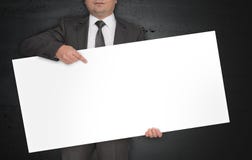 O cartaz vazio é mantido pelo homem de negócios fotos de stock royalty free O cartaz vazio é mantido pelo homem de negócios fotos de stock royalty free