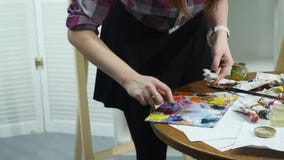 O close-up disparou das mãos fêmeas que espremem para fora um tubo da pintura na paleta vídeos de arquivo O close-up disparou das mãos fêmeas que espremem para fora um tubo da pintura na paleta vídeos de arquivo