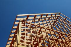 O close-up do telhado de frontões na vara construiu em casa sob a construção e o céu azul foto de stock royalty free O close-up do telhado de frontões na vara construiu em casa sob a construção e o céu azul foto de stock royalty free