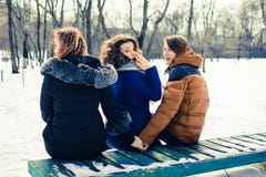 O conceito da imagem da infidelidade marital Os jovens no banco, abraços um e guardam a outra mão do ` s fotos de stock royalty free O conceito da imagem da infidelidade marital Os jovens no banco, abraços um e guardam a outra mão do ` s fotos de stock royalty free
