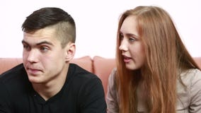 O conflito novo bonito dos pares que senta-se em um sofá discute infeliz filme O conflito novo bonito dos pares que senta-se em um sofá discute infeliz filme