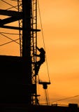 O construtor trabalha no por do sol imagens de stock O construtor trabalha no por do sol imagens de stock