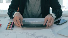 O corretor de imóveis masculino irreconhecível que worling no escritório com bens imobiliários planeia video estoque O corretor de imóveis masculino irreconhecível que worling no escritório com bens imobiliários planeia video estoque