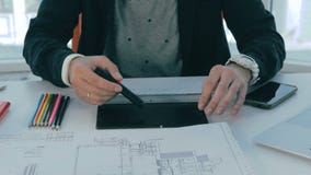 O corretor de imóveis masculino irreconhecível que worling no escritório com bens imobiliários planeia video estoque O corretor de imóveis masculino irreconhecível que worling no escritório com bens imobiliários planeia video estoque