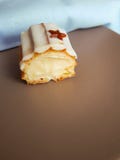 O corte do eclair com o creme da baunilha coberto com o esmalte branco do chocolate foto de stock royalty free O corte do eclair com o creme da baunilha coberto com o esmalte branco do chocolate foto de stock royalty free