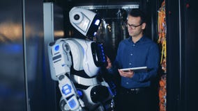 O Cyborg levanta sua mão sob o controle de um coordenador masculino O Cyborg levanta sua mão sob o controle de um coordenador masculino