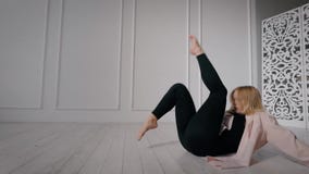 O dançarino contemporâneo fêmea está treinando no salão de dança apenas, sentando-se no assoalho, os pés moventes acima video estoque O dançarino contemporâneo fêmea está treinando no salão de dança apenas, sentando-se no assoalho, os pés moventes acima video estoque