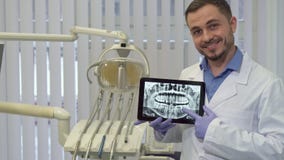O dentista aponta seu dedo no raio X fotos de stock O dentista aponta seu dedo no raio X fotos de stock