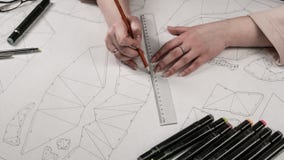 O desenhista fêmea faz um desenho de trabalho Local de trabalho de um desenhista do brinquedo Os marcadores, a régua, a pena e o imagens de stock O desenhista fêmea faz um desenho de trabalho Local de trabalho de um desenhista do brinquedo Os marcadores, a régua, a pena e o imagens de stock