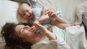 O desenvolvimento das crianças Jogos felizes da mãe com o pé do bebê que encontra-se na cama Crianças que contam, uma mulher vídeos de arquivo O desenvolvimento das crianças Jogos felizes da mãe com o pé do bebê que encontra-se na cama Crianças que contam, uma mulher vídeos de arquivo
