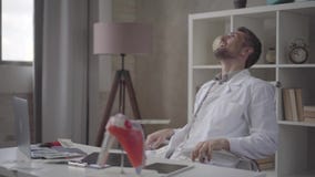 O doutor farpado bem sucedido, satisfeito feliz considerável dispersa os dólares que sentam-se em uma cadeira em uma tabela de tr vídeos de arquivo O doutor farpado bem sucedido, satisfeito feliz considerável dispersa os dólares que sentam-se em uma cadeira em uma tabela de tr vídeos de arquivo