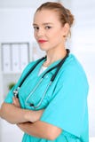 O doutor fêmea do cirurgião está estando com os braços cruzados e está sorrindo no hospital Médico pronto para examinar o pacient fotos de stock royalty free O doutor fêmea do cirurgião está estando com os braços cruzados e está sorrindo no hospital Médico pronto para examinar o pacient fotos de stock royalty free