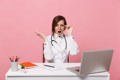 O doutor fêmea triste cansado senta-se no trabalho de mesa no computador com documento médico no hospital isolado na parede cor-d imagem de stock O doutor fêmea triste cansado senta-se no trabalho de mesa no computador com documento médico no hospital isolado na parede cor-d imagem de stock
