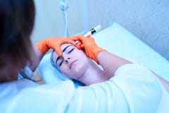 O doutor nas luvas faz às sobrancelhas tattooing uma menina bonita que l imagens de stock royalty free O doutor nas luvas faz às sobrancelhas tattooing uma menina bonita que l imagens de stock royalty free
