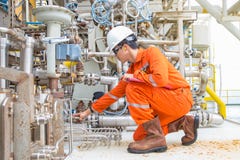 O engenheiro mecânico que verifica e inspeciona o sistema do óleo lubrificante de compressor de gás centrífugo na plataforma a po fotos de stock O engenheiro mecânico que verifica e inspeciona o sistema do óleo lubrificante de compressor de gás centrífugo na plataforma a po fotos de stock