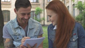 O estudante masculino escreve algo em seu caderno fotografia de stock royalty free O estudante masculino escreve algo em seu caderno fotografia de stock royalty free