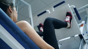 O exercício na máquina da imprensa do pé, desportista levanta a plataforma pesada no gym video estoque O exercício na máquina da imprensa do pé, desportista levanta a plataforma pesada no gym video estoque