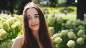 O fim acima do modelo moreno desenvolve seus cabelo e olhares na câmera com um sorriso filme O fim acima do modelo moreno desenvolve seus cabelo e olhares na câmera com um sorriso filme