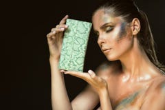 O fim acima do retrato da mulher lindo com olhos fechados e o snakeskin artístico compõem guardar a bolsa de couro verde em sua c Imagem de Stock O fim acima do retrato da mulher lindo com olhos fechados e o snakeskin artístico compõem guardar a bolsa de couro verde em sua c Imagem de Stock